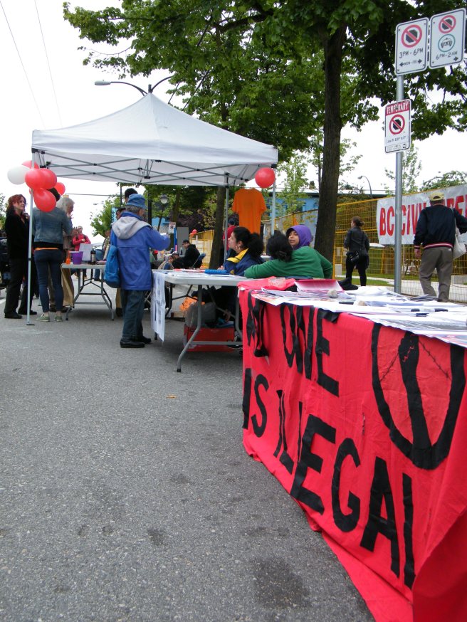 Community groups set up along the street, including No One is Illegal.