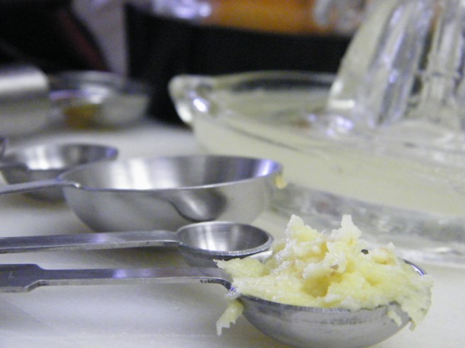 A teaspoon full of ginger, with the rest of the set in view, along with a glass juicer full of lime juice and the bottom of the blender full of melon. A teaspoon full of ginger, with the rest of the set in view, along with a glass juicer full of lime juice and the bottom of the blender full of melon.