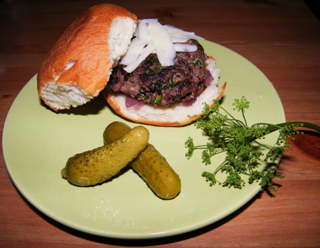 The finished burger, with cornichons and a dill flower for garnish. The finished burger, with cornichons and a dill flower for garnish.