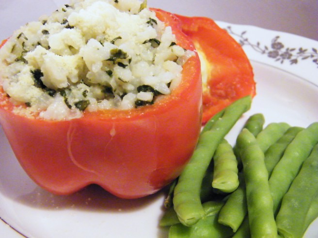 A red pepper stuffed with the rice, accompanied by green beans.