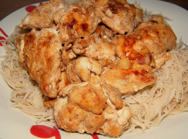 Chicken atop brown rice vermicelli.