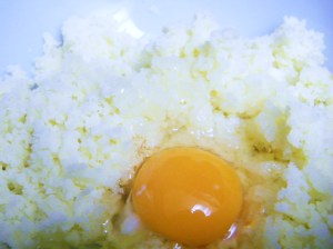 Adding the egg yolk to the potato.