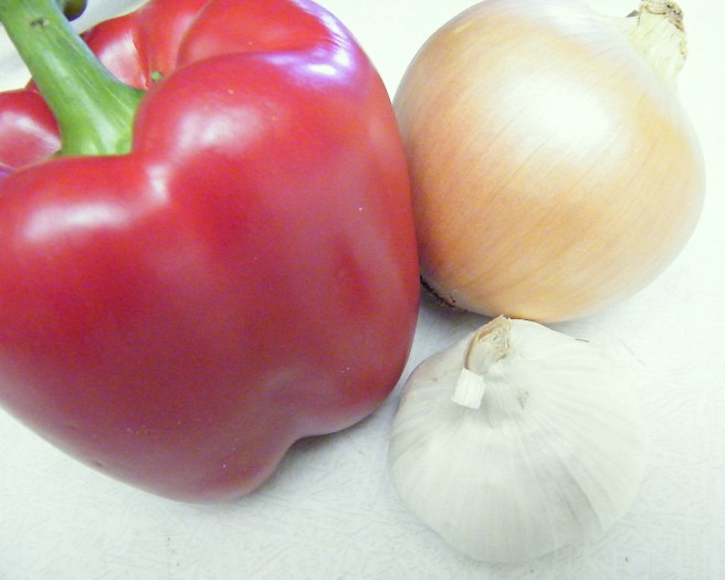 The onion, red pepper, and garlic before their introduction to the cutting board. The onion, red pepper, and garlic before their introduction to the cutting board.
